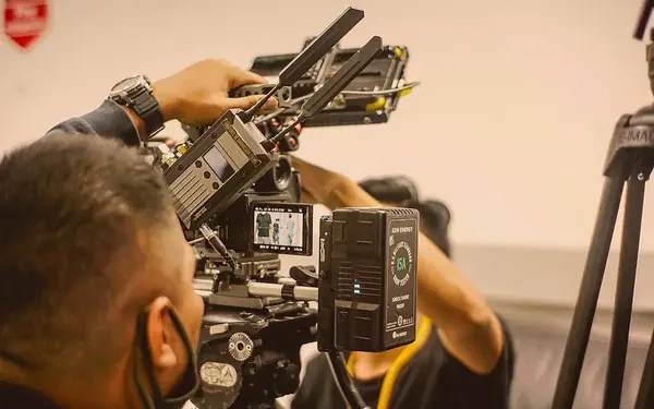 A film crew gathered around a cinema camera on set